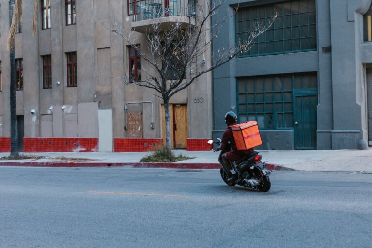 Entregador de aplicativo em motocicleta na cidade