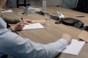 Trabalhador assinando documento de demissão sob pressão da empresa