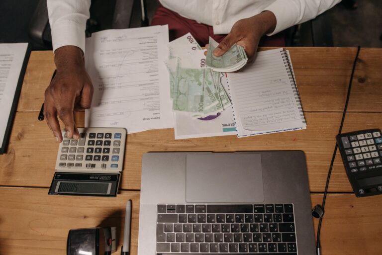 Trabalhador calculando salário e contracheque com calculadora, representando o reajuste do salário mínimo em 2027