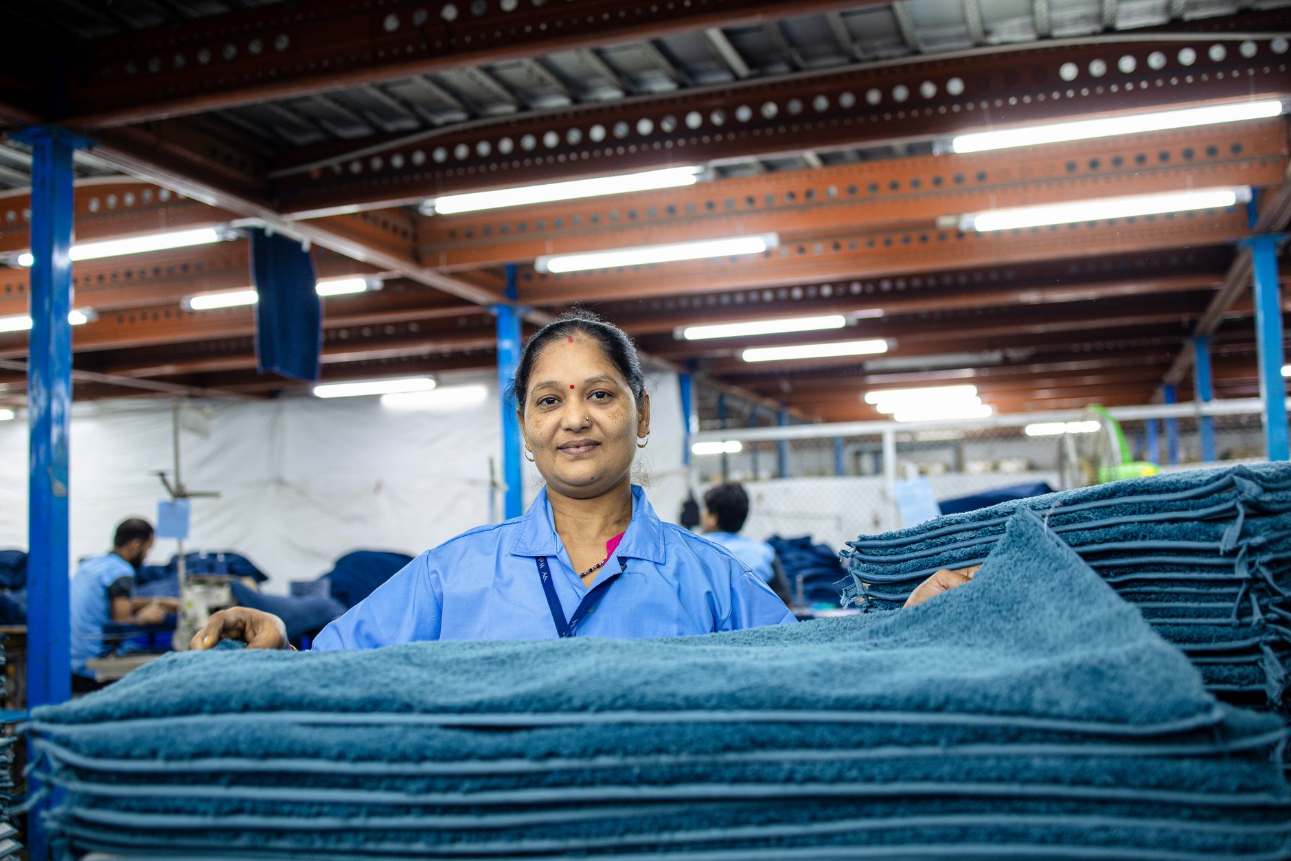 Trabalhador sorridente em ambiente de fábrica, representando o trabalhador CLT que recebe salário mínimo