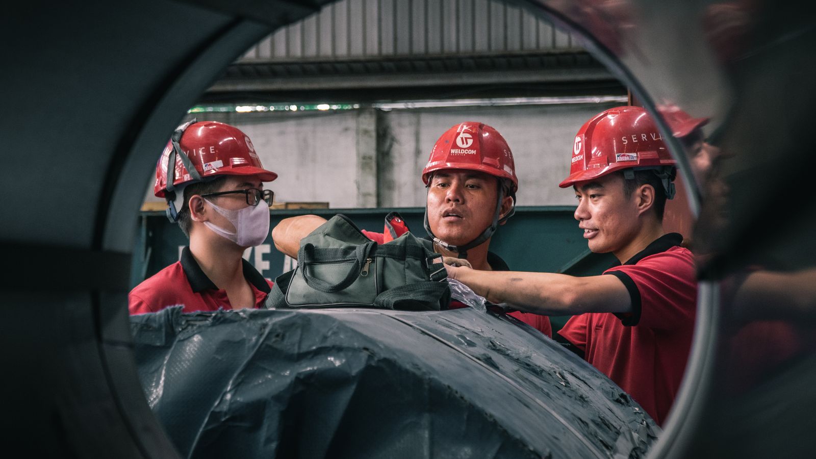 Trabalhadores de capacete em ambiente industrial, exemplo de atividade com direito a adicional de insalubridade ou periculosidade