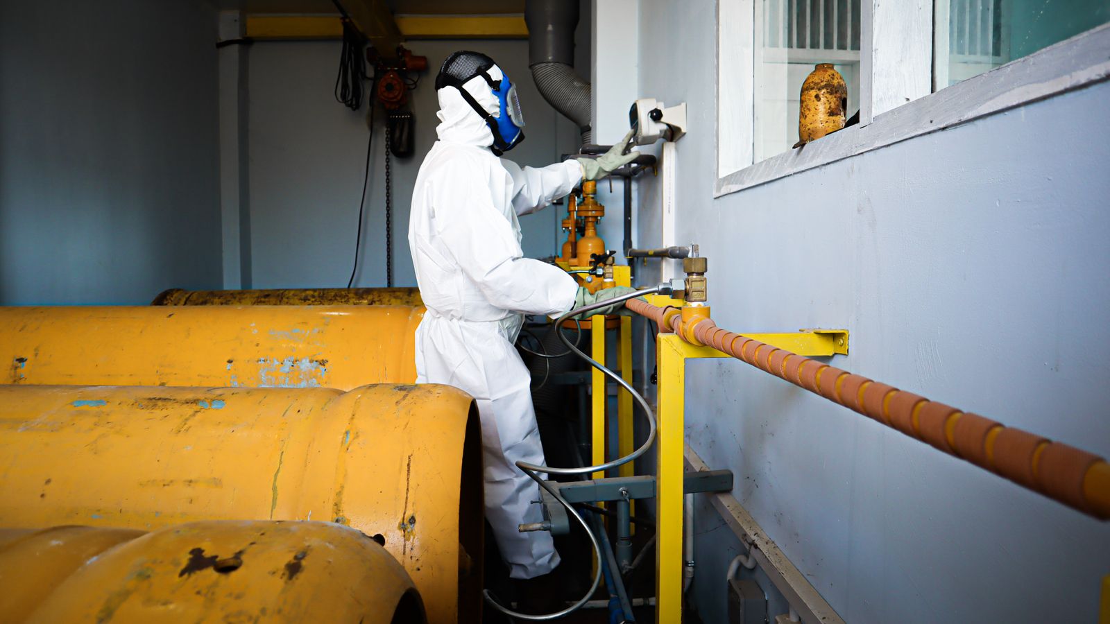 Trabalhador com equipamento de proteção completo em ambiente insalubre