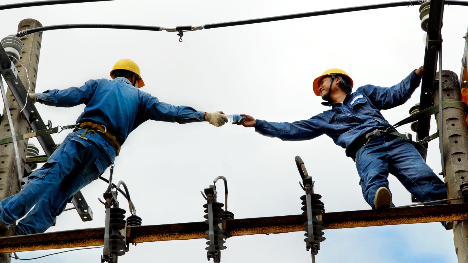 Eletricistas trabalhando em rede elétrica, atividade que gera direito ao adicional de periculosidade