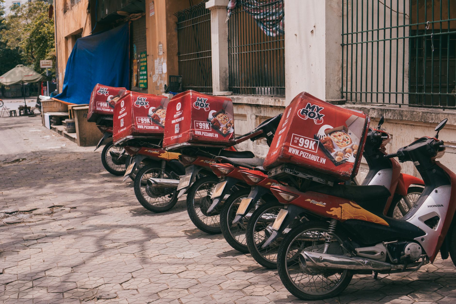 Entregador de moto carregando caixa em via pública