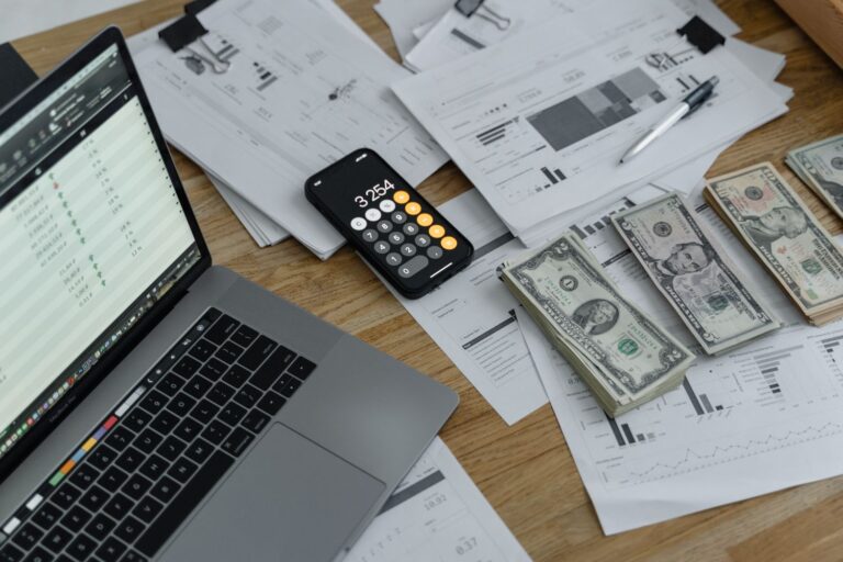 Documentos financeiros, calculadora e dinheiro sobre a mesa representando o cálculo do desconto do empréstimo consignado na rescisão trabalhista