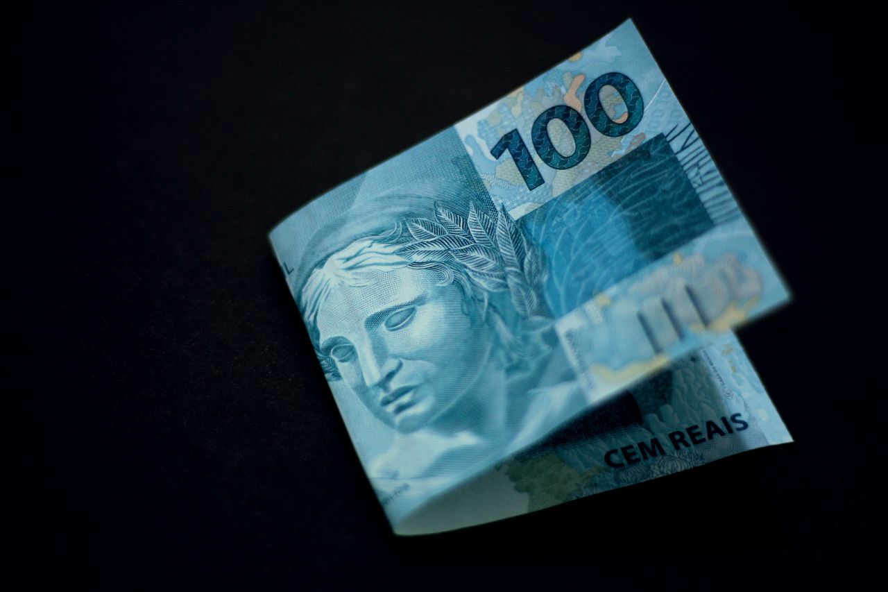 Nota de cem reais representando o salário do trabalhador protegido por lei