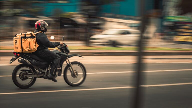 Entregador de aplicativo em motocicleta com bag de entrega