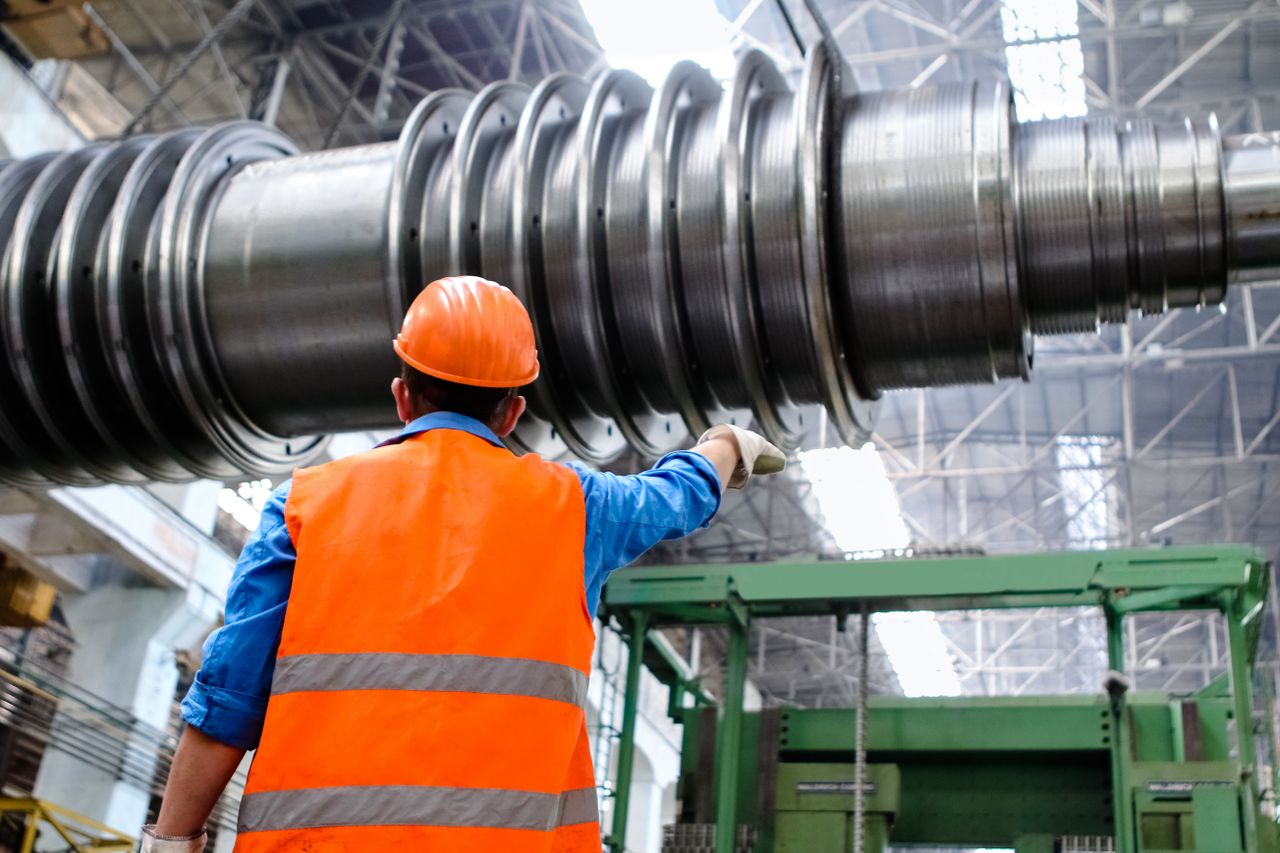 Operário de capacete trabalhando dentro de uma fábrica