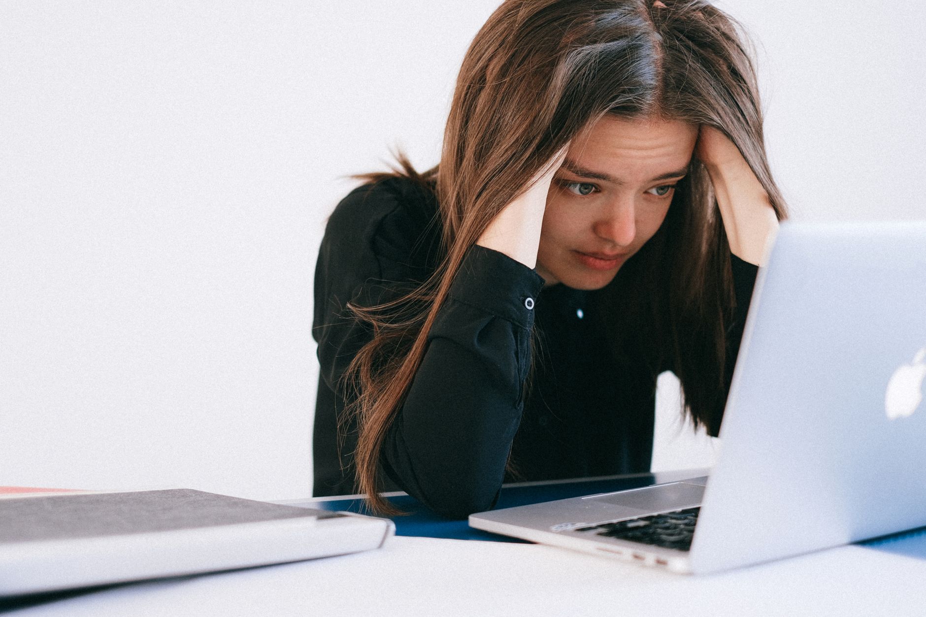Mulher pensativa no ambiente de trabalho após ser demitida