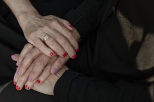 Duas pessoas de luto dão as mãos em sinal de apoio