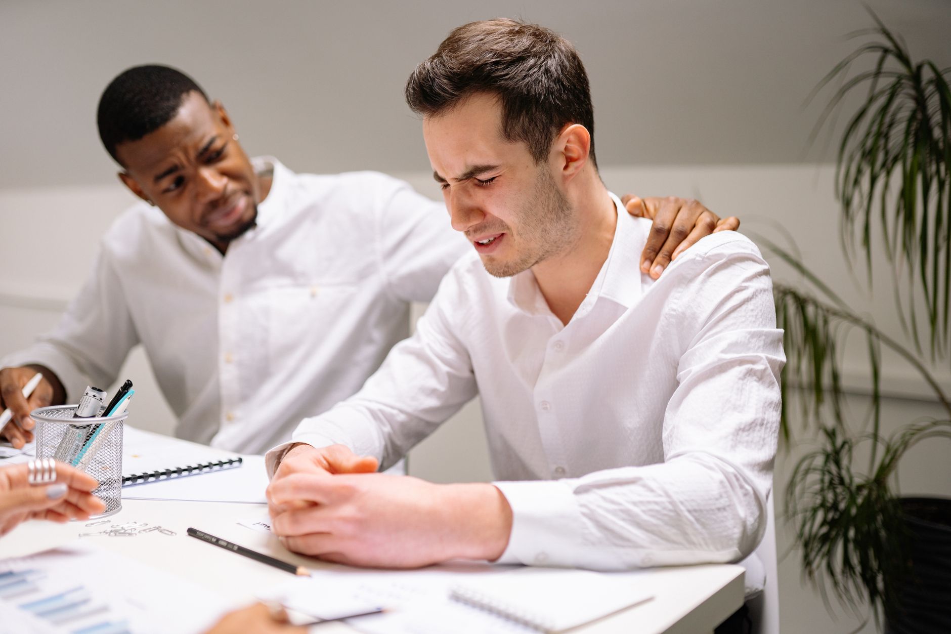 Colega de trabalho apoiando outro colega em momento difícil no escritório