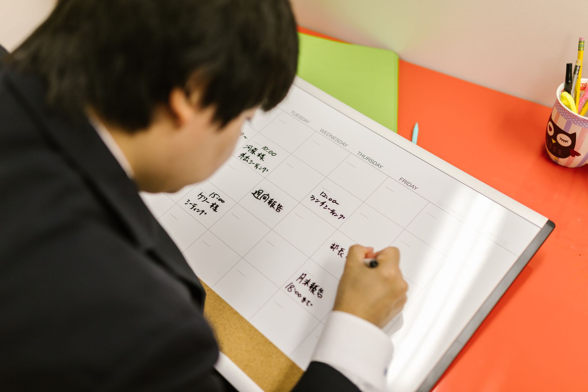 Pessoa organizando planejamento semanal em agenda
