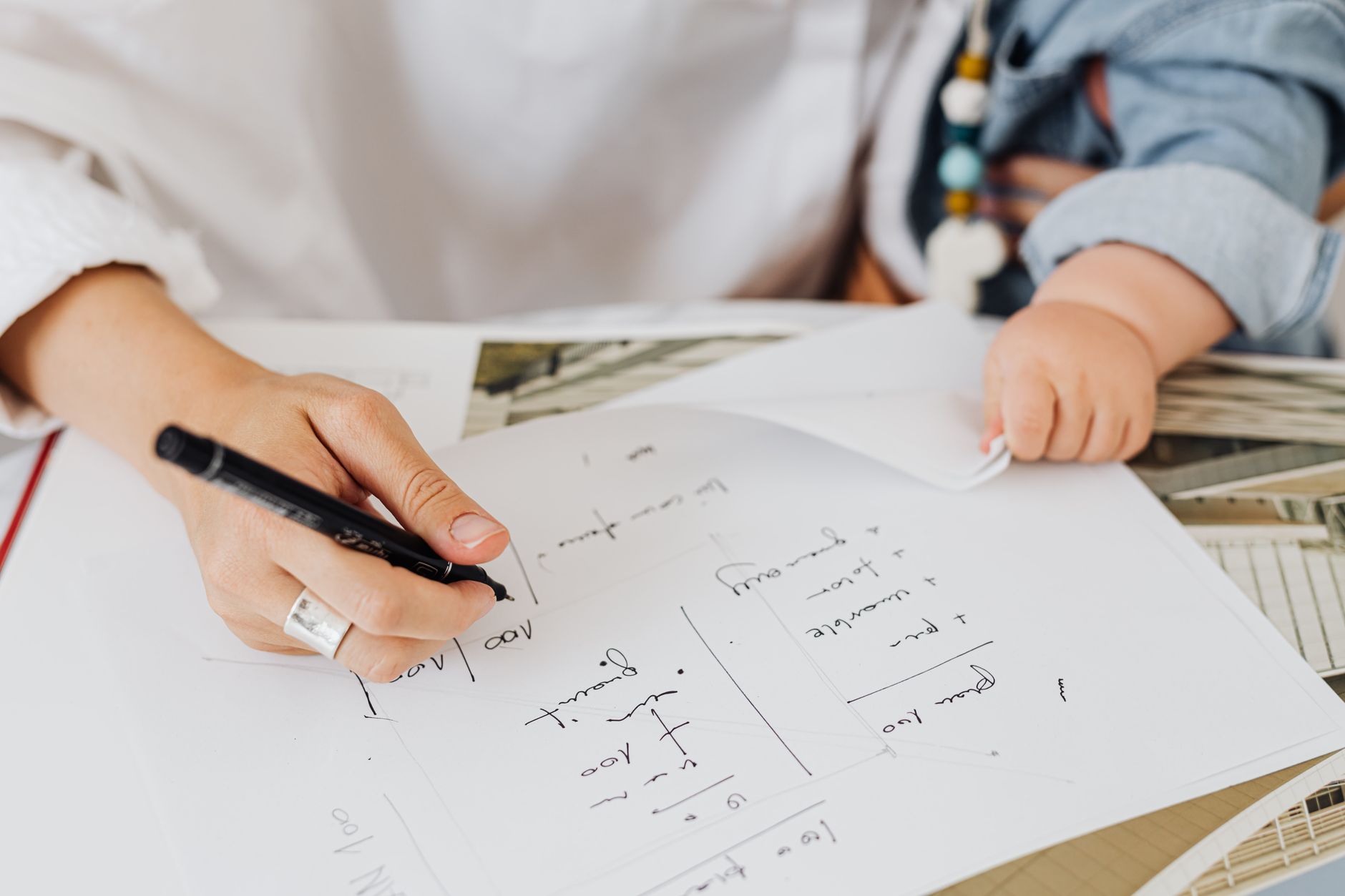 Mãe trabalhando com o bebê ao lado em ambiente de escritório