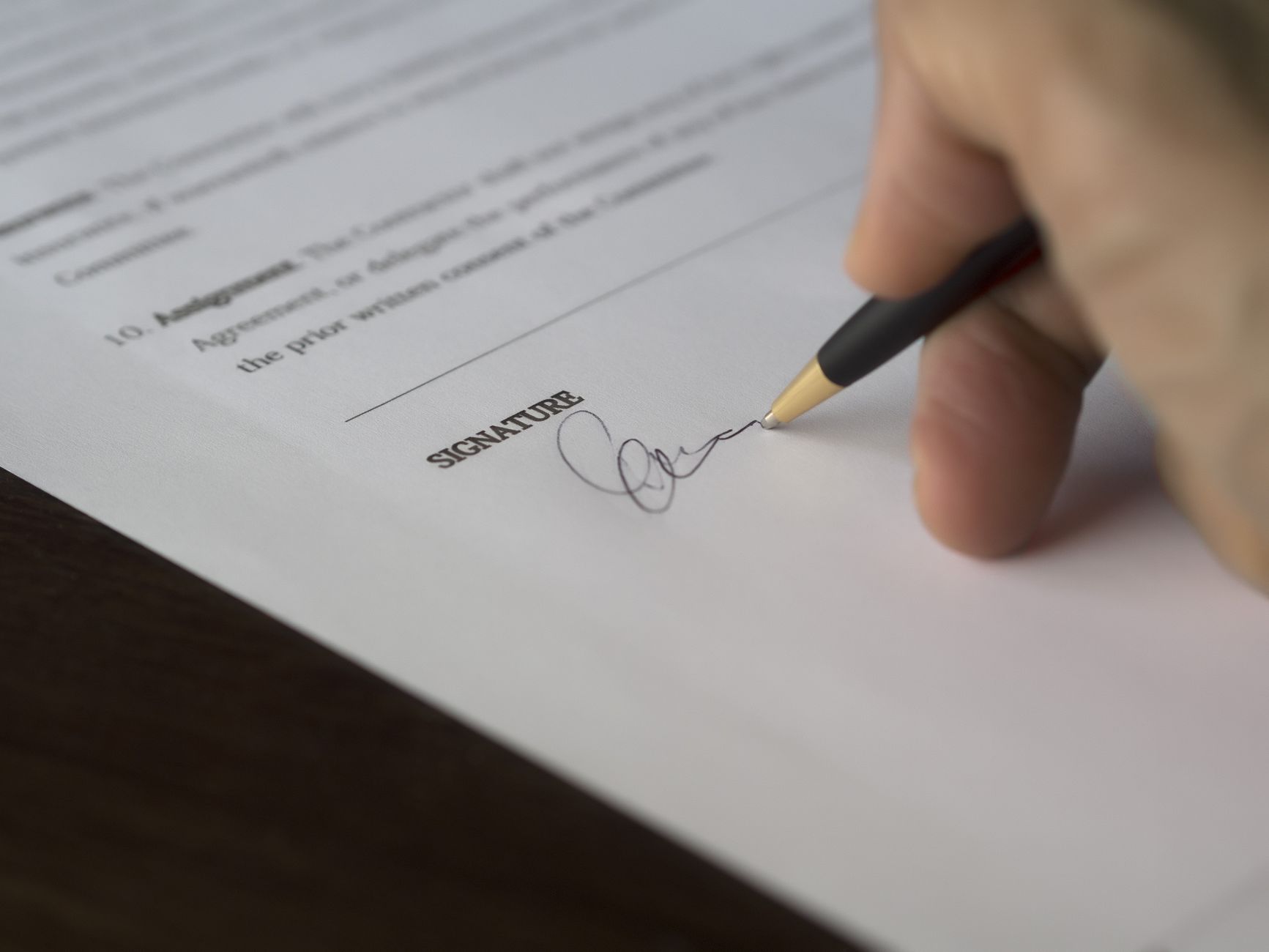 Duas pessoas assinando contrato de trabalho em escritório