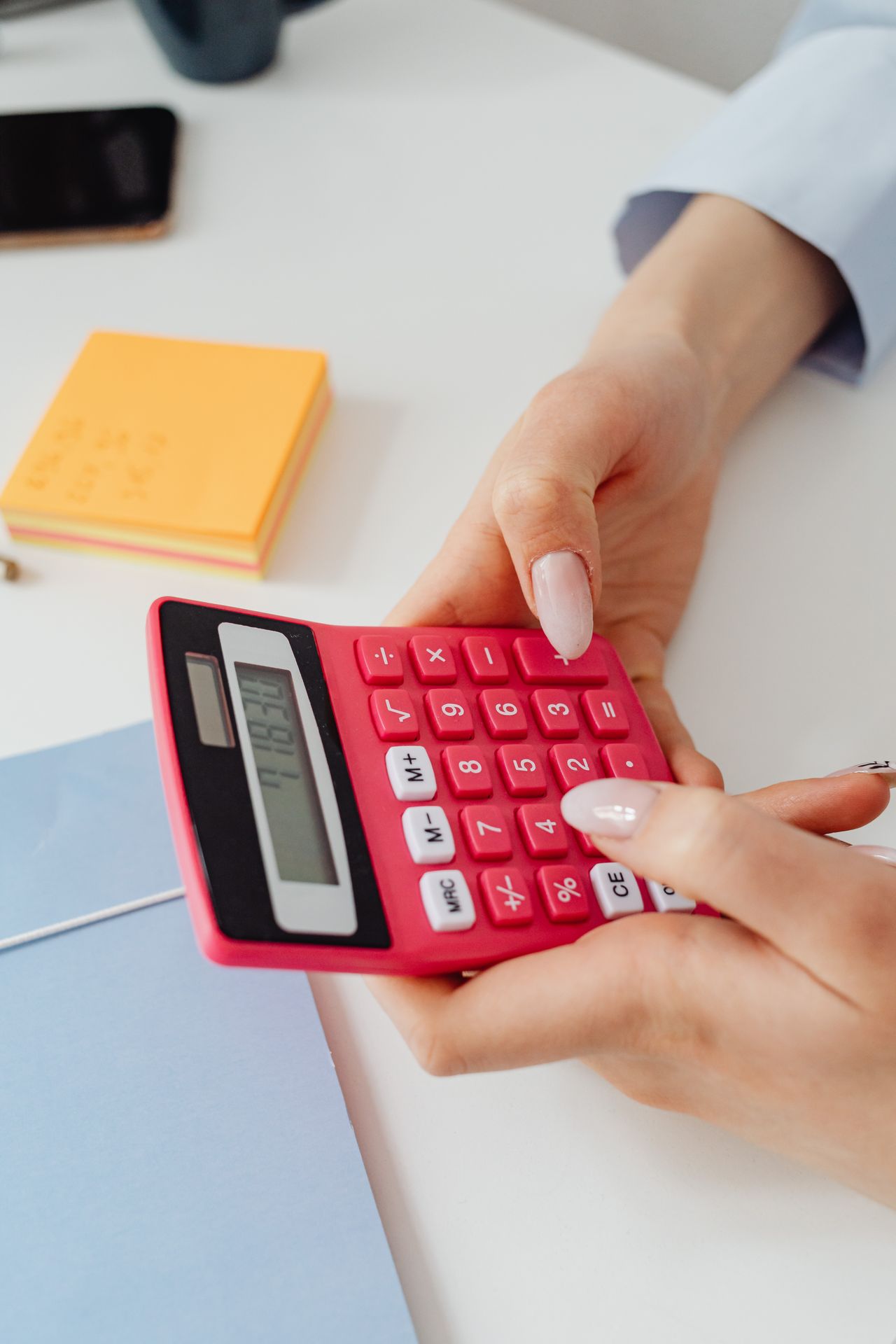 Mãos segurando calculadora para conferir valores de pagamento