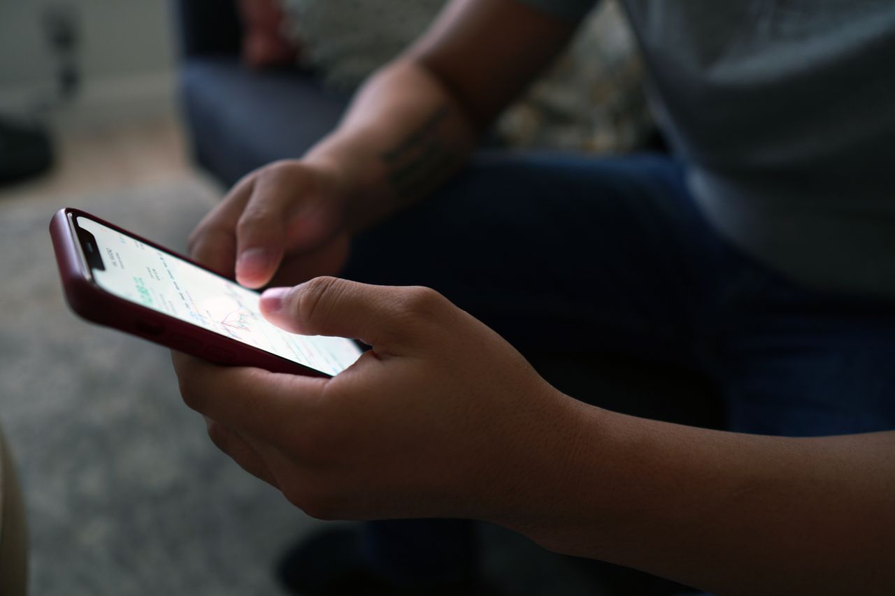 Homem segurando celular com a tela em branco, representando a checagem de mensagens como prova trabalhista