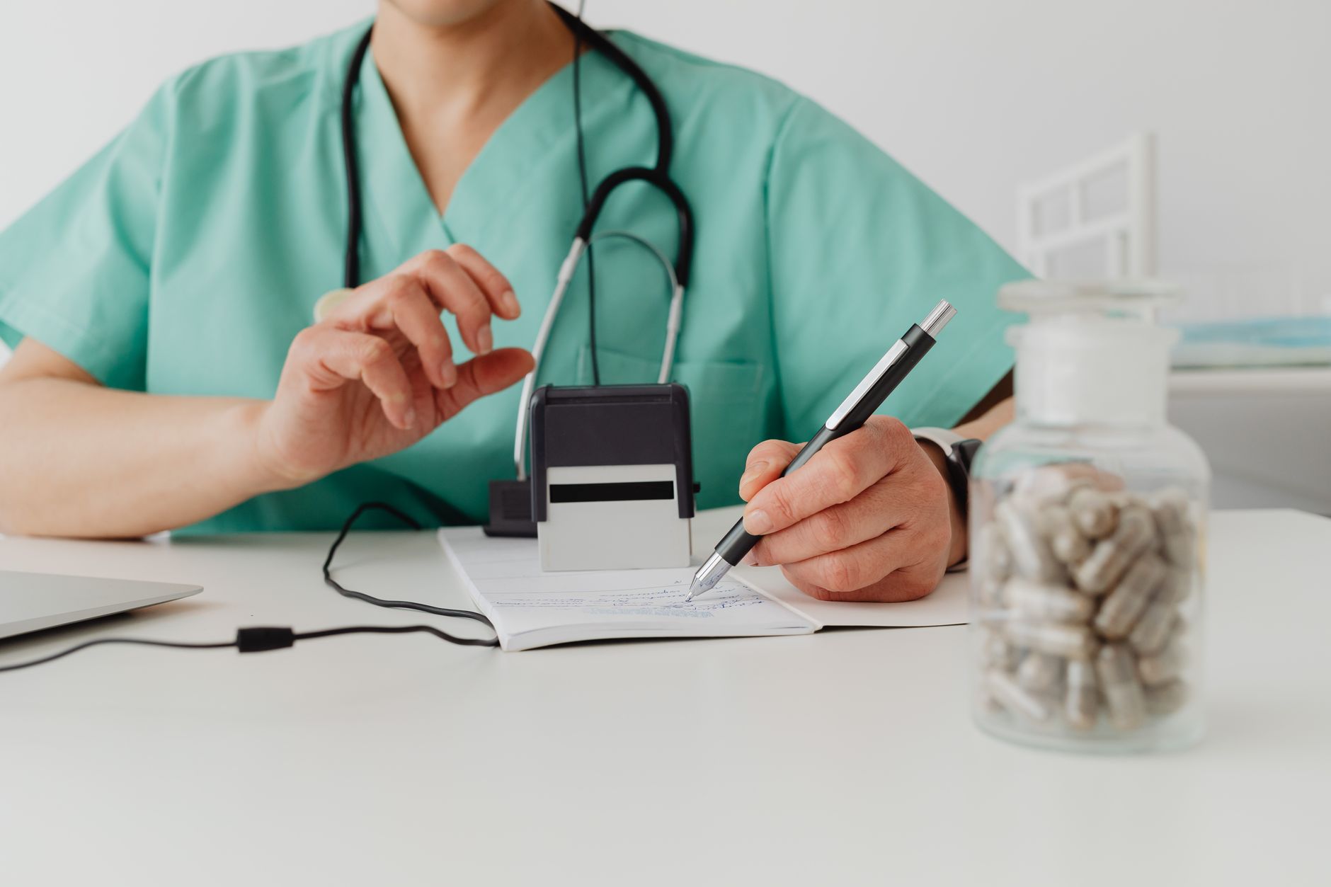 Médico preenchendo atestado médico para paciente afastado do trabalho