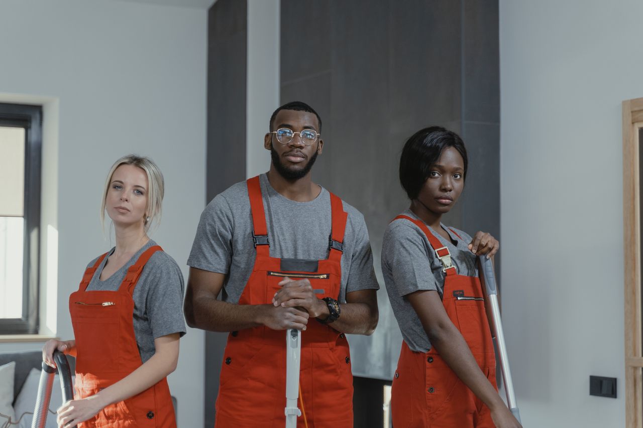 Equipe de trabalhadores da limpeza com uniforme durante a jornada de trabalho