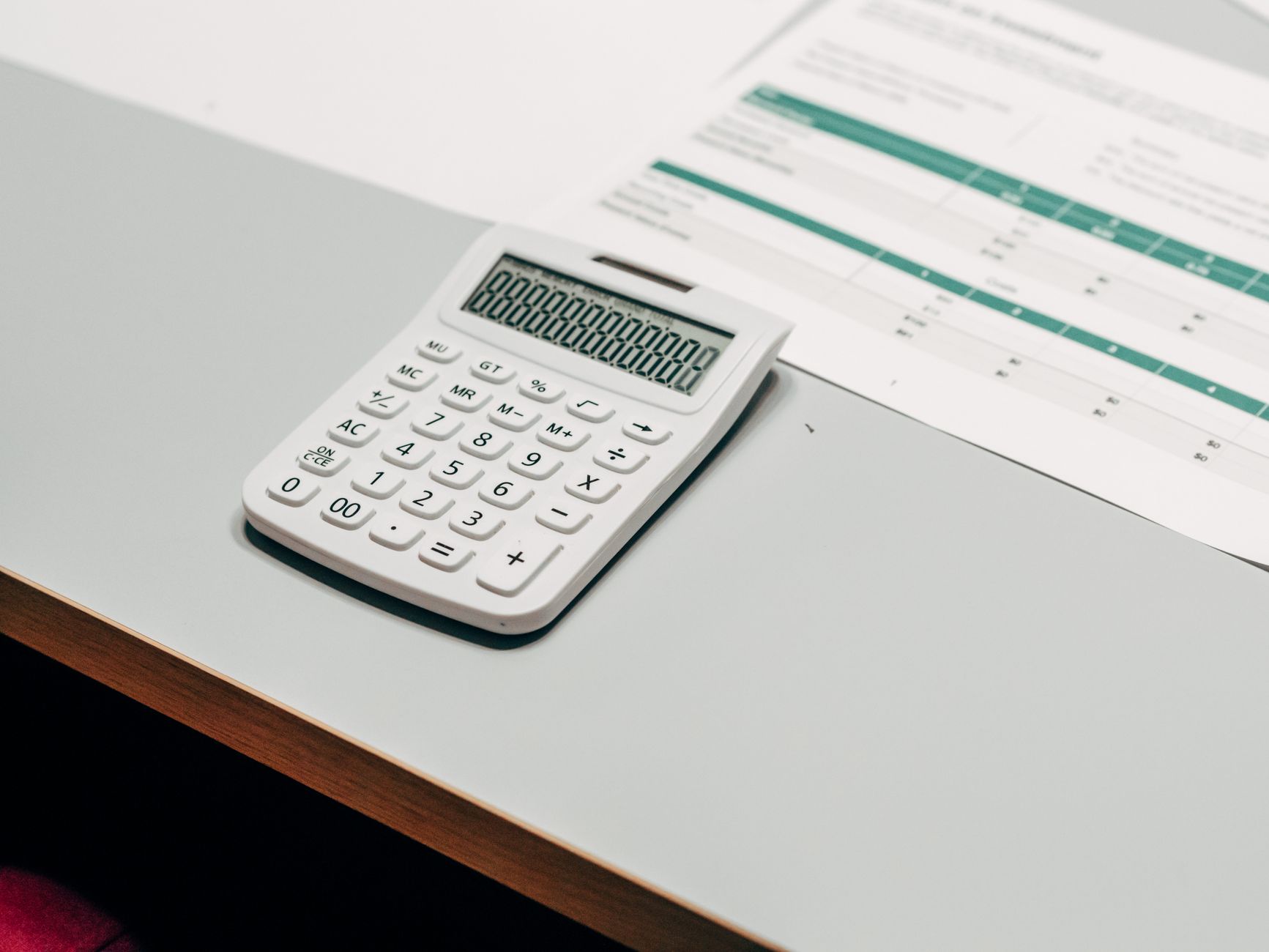 Contracheque e calculadora sobre a mesa representando conferência de salário