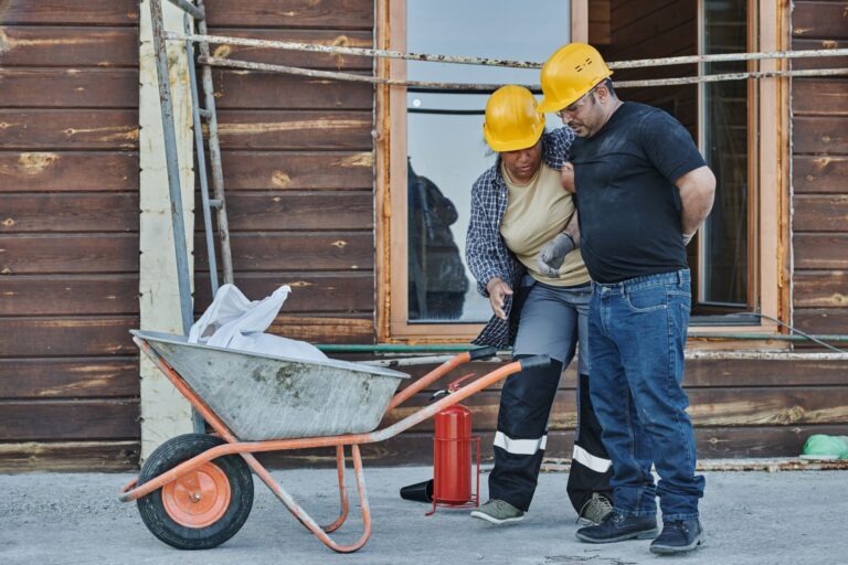 Colegas de trabalho auxiliando trabalhador acidentado em canteiro de obras