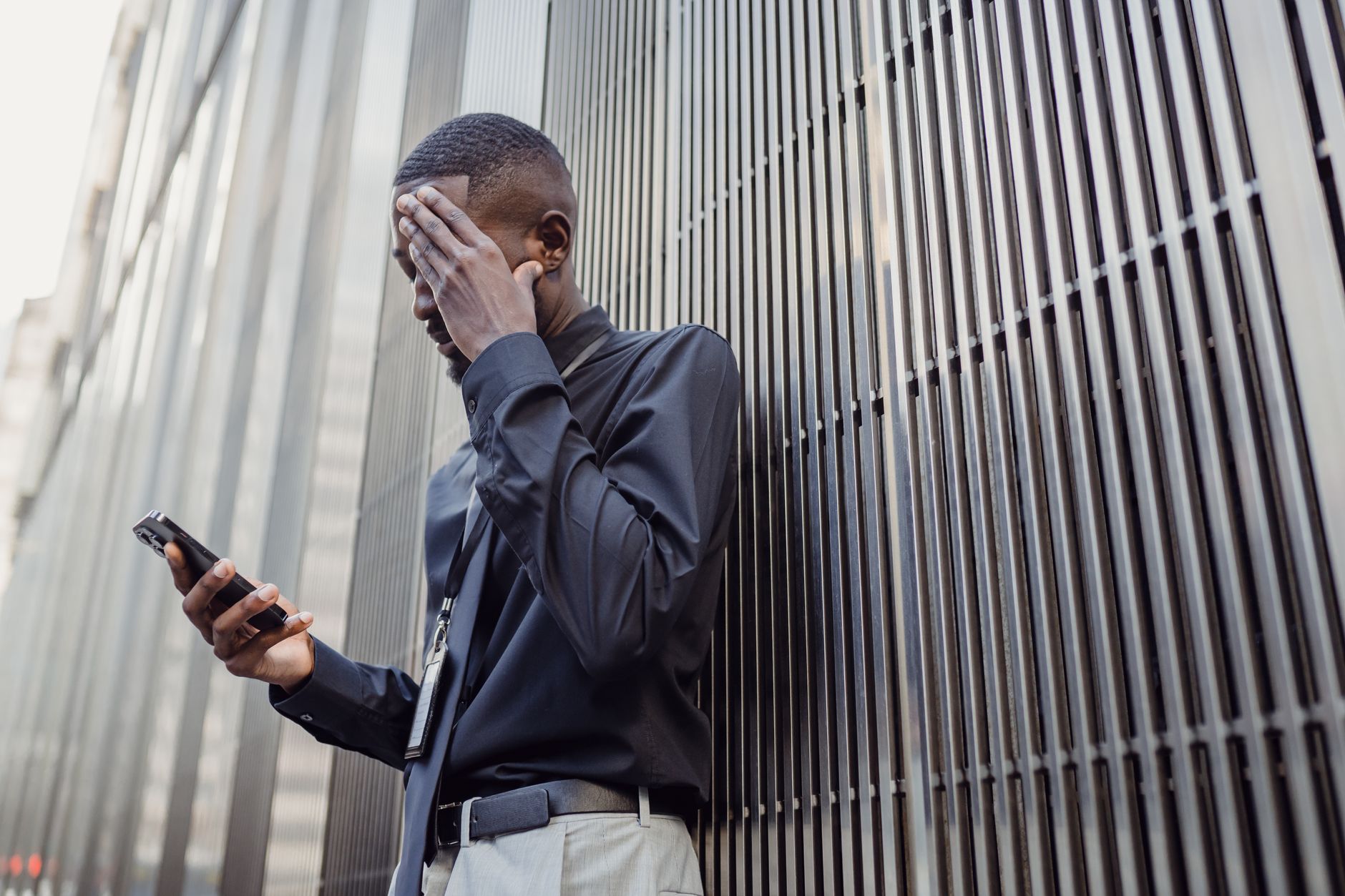 Trabalhador preocupado olhando o celular no ambiente de trabalho