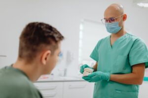 Dentista atendendo paciente em consultório odontológico