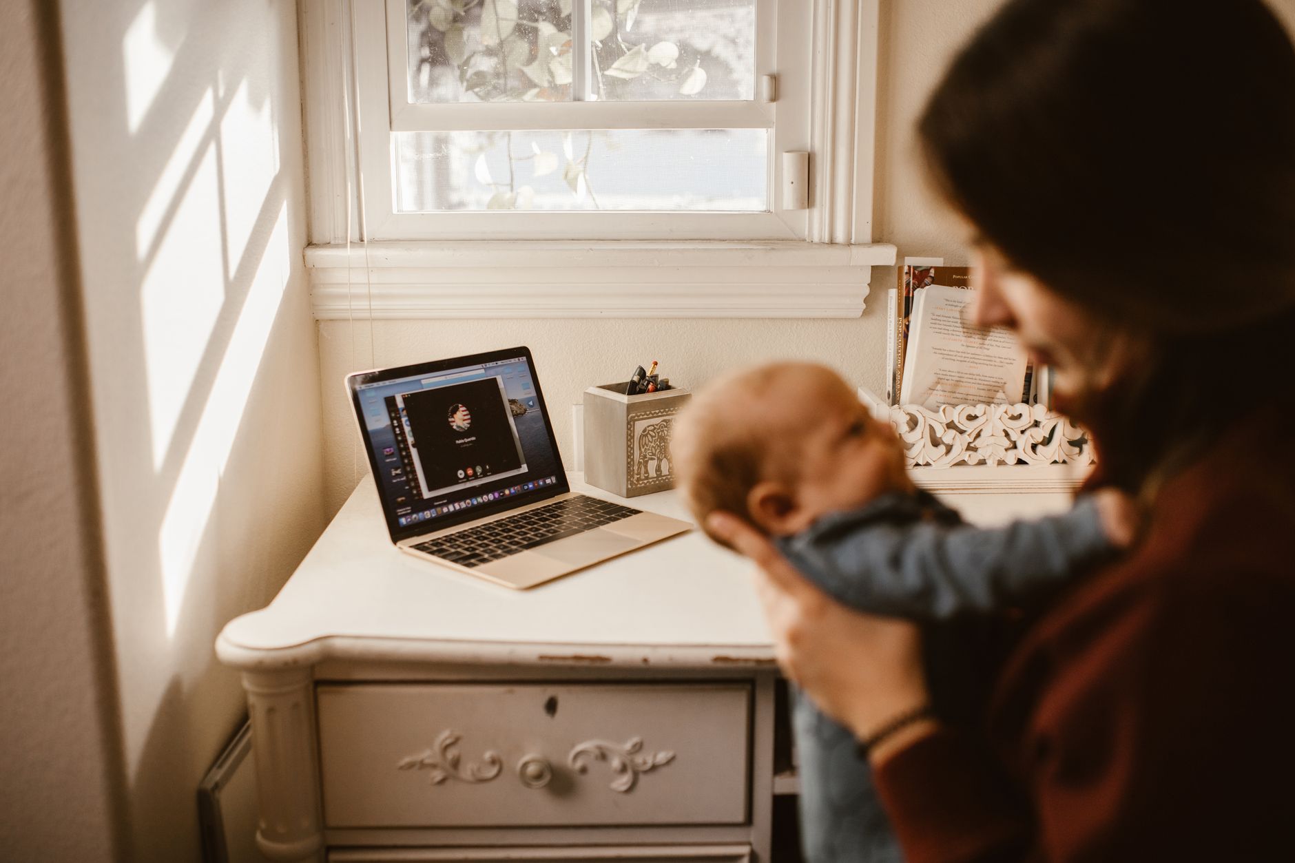 Trabalhadora segurando o filho pequeno no ambiente de trabalho