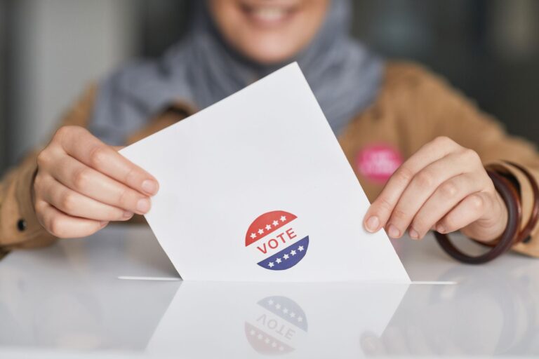 Mulher depositando o comprovante de voto na urna eleitoral