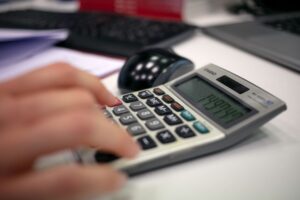 Pessoa usando calculadora para conferir valores de rescisão trabalhista