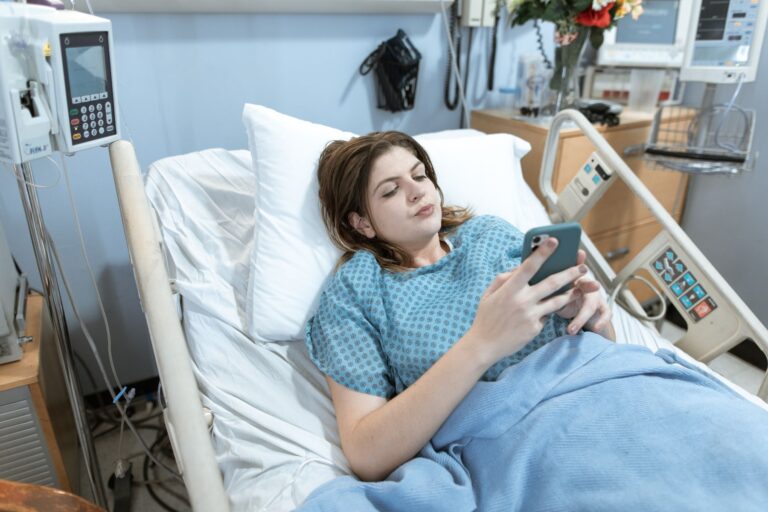 Trabalhadora doente na cama usando o celular durante atestado médico