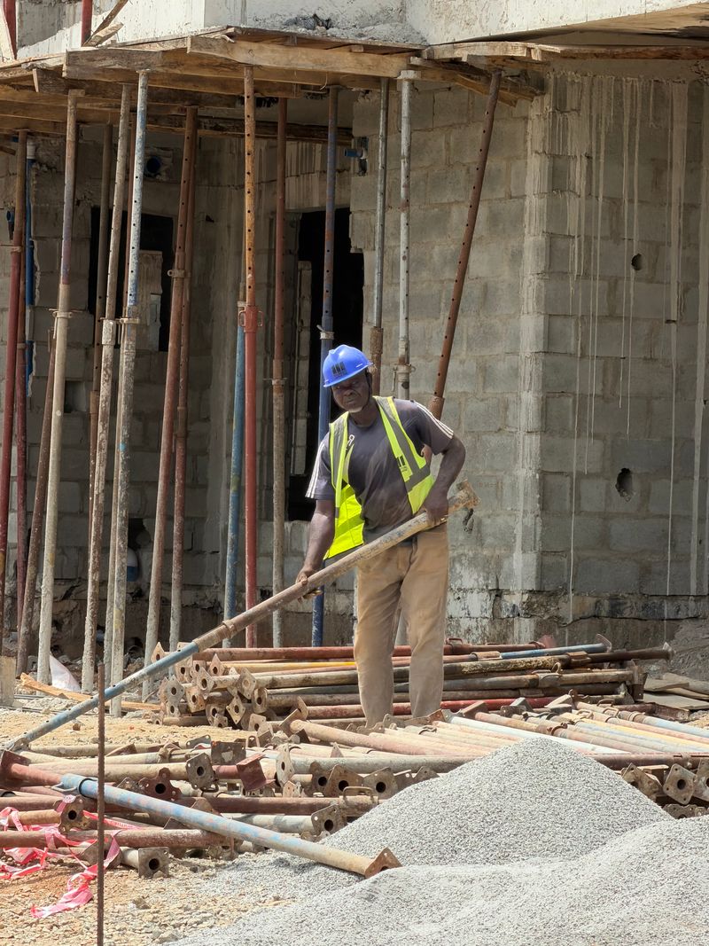 Trabalhador em canteiro de obras com capacete, representando trabalhadores em greve por acordo coletivo