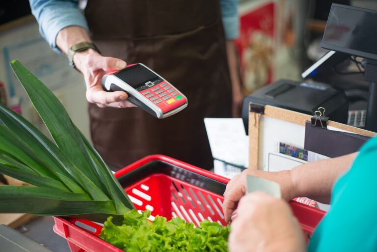 Operador de caixa atendendo cliente em supermercado