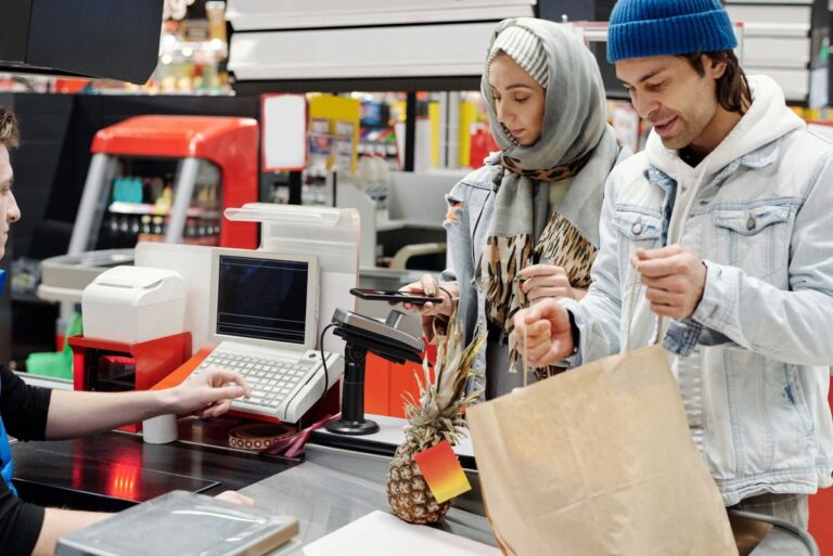Operador de caixa atendendo clientes em supermercado, ilustrando jornada de trabalho no comércio
