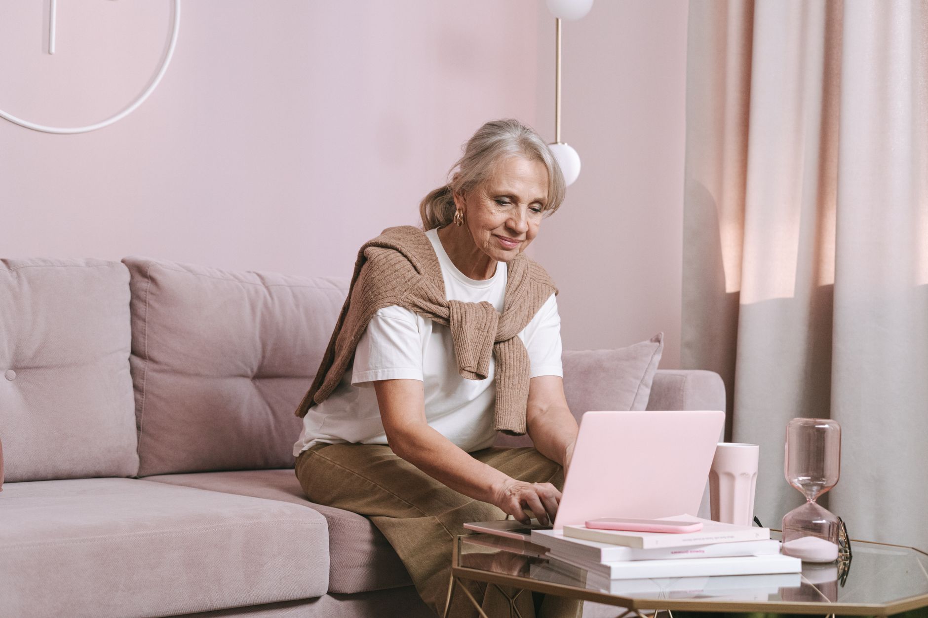 Mulher aposentada consultando o extrato de contribuições pelo notebook em casa