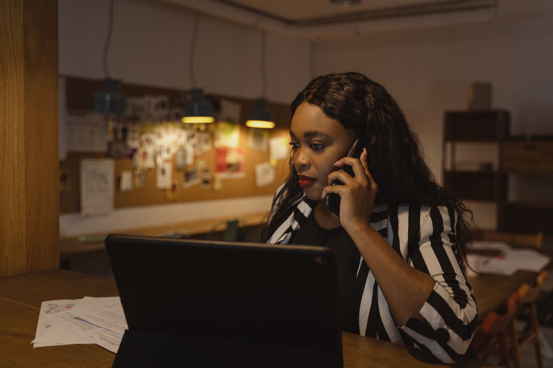 Mulher em ambiente de escritório fazendo uma ligação telefônica de trabalho