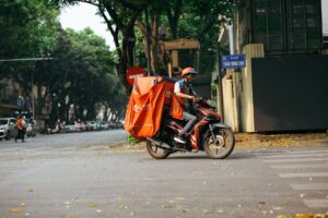 Entregador de motocicleta em via urbana, representando trabalhador sem carteira assinada