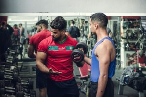 Personal trainer orientando aluno durante treino na academia