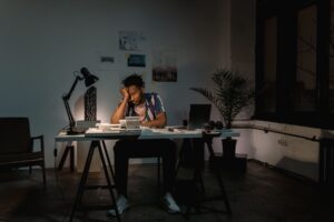 Trabalhador exausto em mesa de escritorio apos jornada excessiva de trabalho