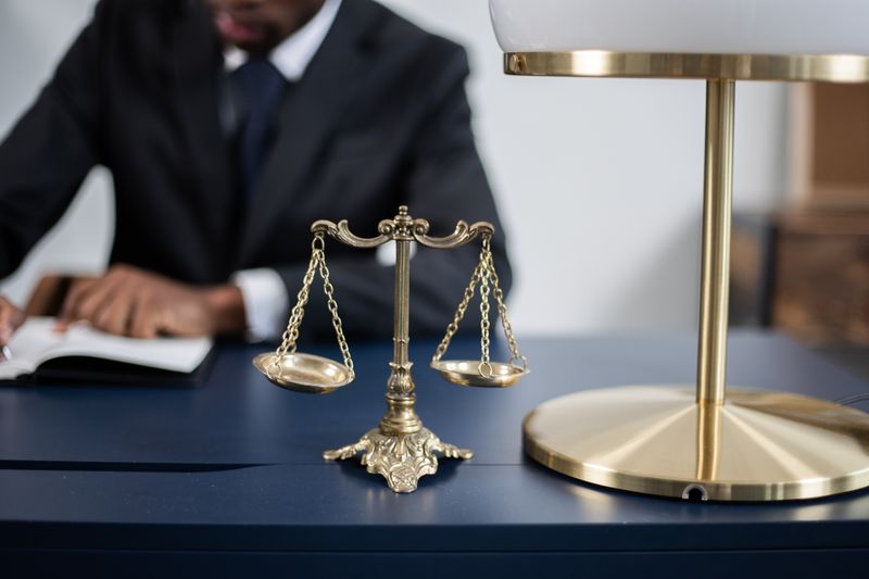 Balança da justiça sobre mesa de escritório de advocacia