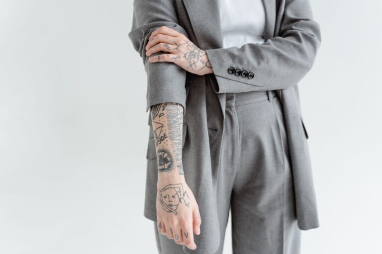 Braço com tatuagens de trabalhador vestindo terno