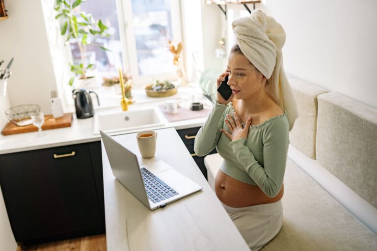 Mulher gravida falando ao telefone celular, representando trabalhadora gestante em situacao de conflito com a empresa