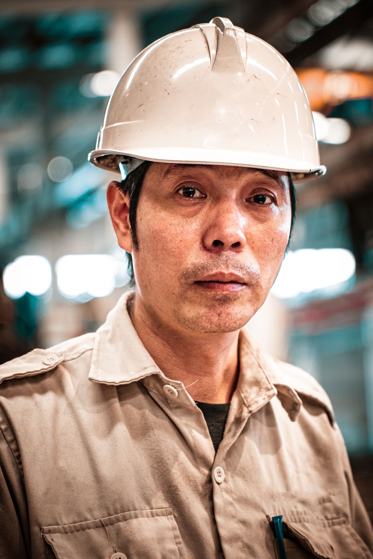 Trabalhador industrial de capacete em retrato dentro de galpão