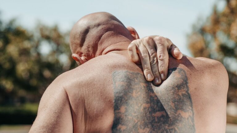 Homem com a mão nas costas sentindo dor