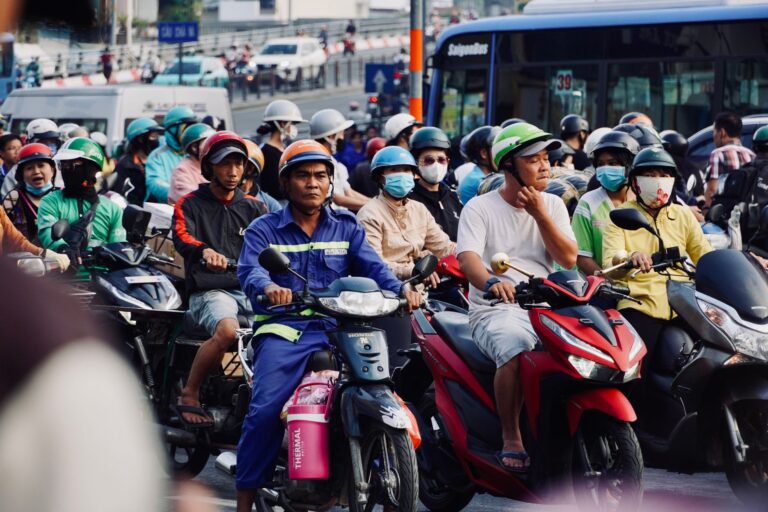 Rua movimentada de cidade com muitos motociclistas no horário de pico