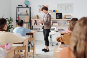 Professora em sala de aula conversando com alunos
