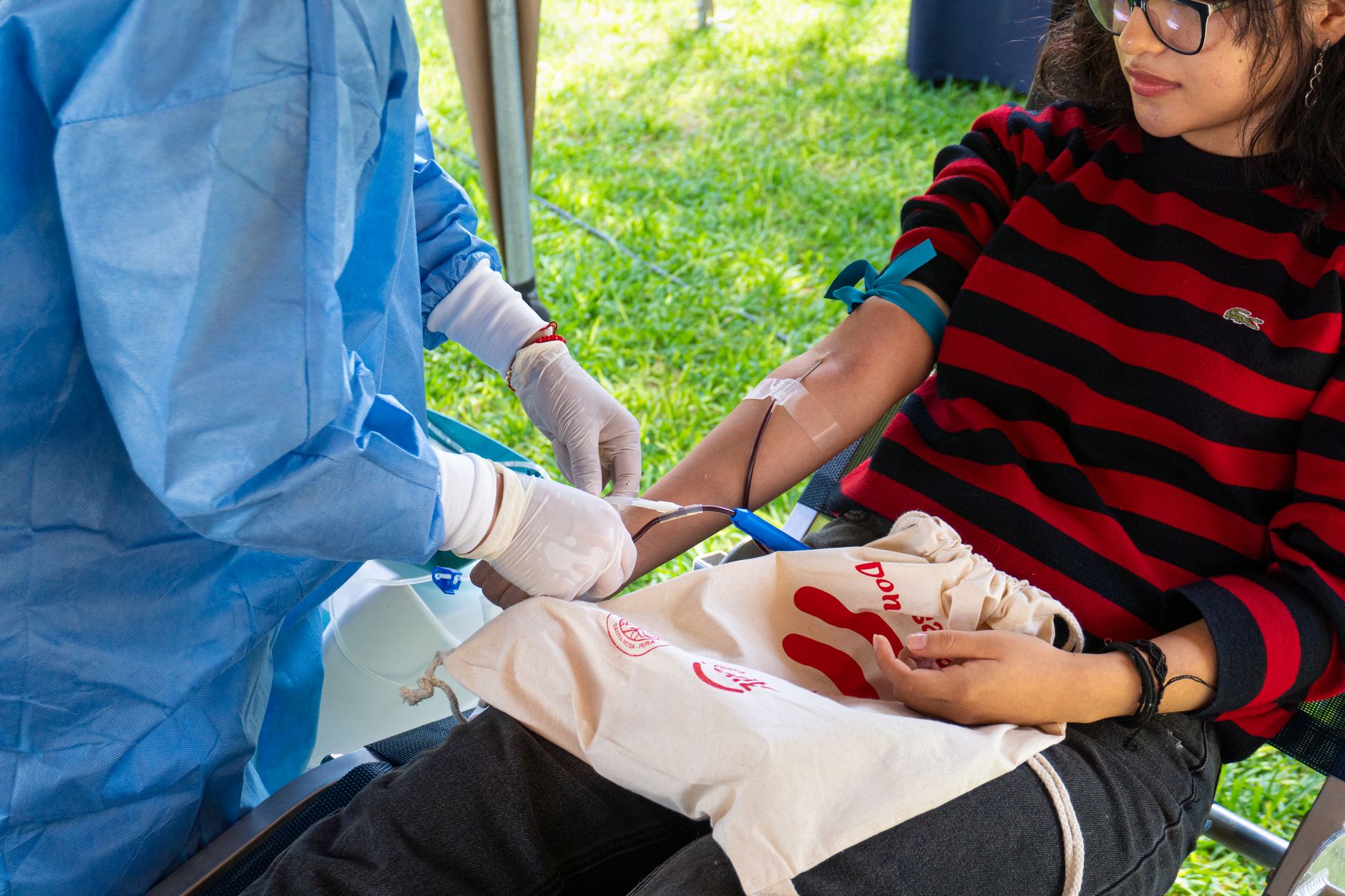 Profissional de saúde coletando sangue em doação voluntária