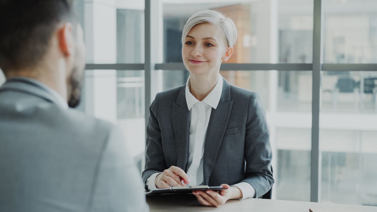 Recrutadora entrevistando candidato em escritório moderno