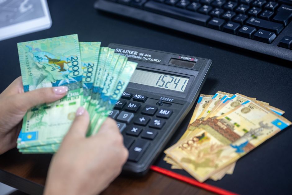 Calculadora e dinheiro sobre a mesa para calcular o valor das férias