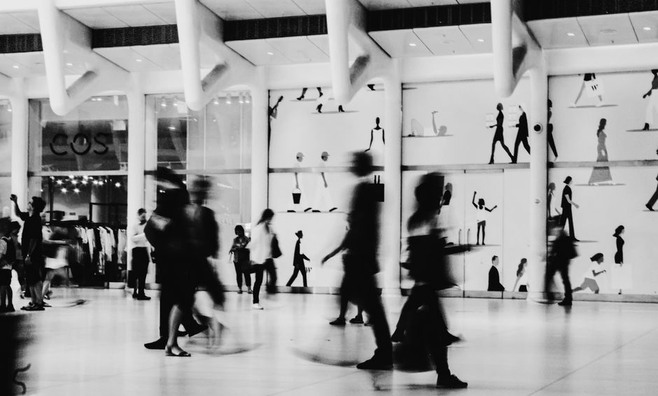 Corredor de shopping center com lojas e clientes