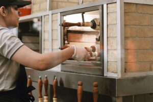 Trabalhadora operando forno de pizzaria